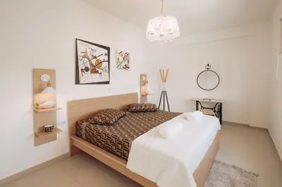 a bedroom with a bed in a white room at ARETOUSA Seafront House in Kalyves