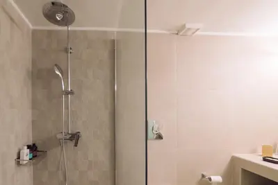 a shower with a glass door in a bathroom at ARETOUSA Seafront House in Kalyves