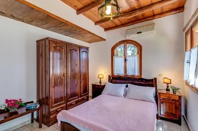 a bedroom with a bed with wooden furniture and a window at Natalia's Houses in Chania Town