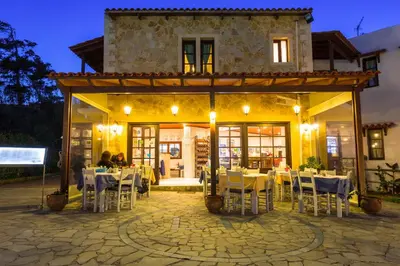 a restaurant with tables and chairs in front of a building at Ledra Maleme Hotel in Maleme