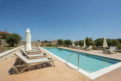 a swimming pool with chaise lounge chairs and a swimming pool at Villa Andromeda Fres in Frés