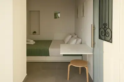 a small bedroom with a bed and a desk at Yalos Tiny Studio - 5 mins to Elafonisi beach in Agios Padeleimon