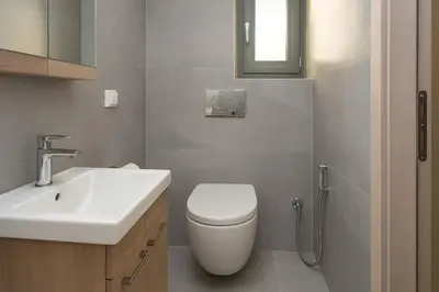 a bathroom with a white toilet and a sink at Yalos Tiny Studio - 5 mins to Elafonisi beach in Agios Padeleimon