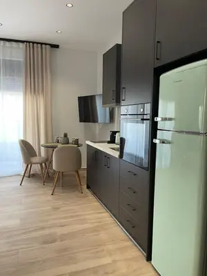 a kitchen with a refrigerator and a table at Casa Nero in Chania Town