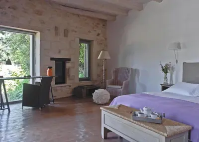 a bedroom with a large bed and a fireplace at Villa Athermigo in Gavalochori