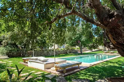 a swimming pool in a yard with a couch and a swing at Villa Athermigo in Gavalochori