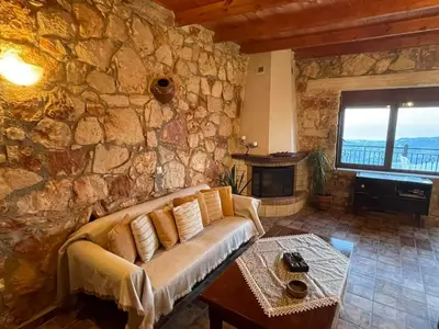 a living room with a couch and a stone wall at Viewphoria in Maláxa