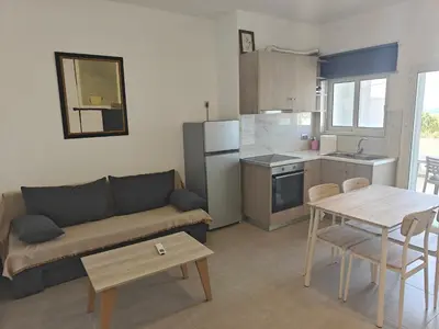 a living room with a couch and a table at Chrissos apartment in Agios Padeleimon