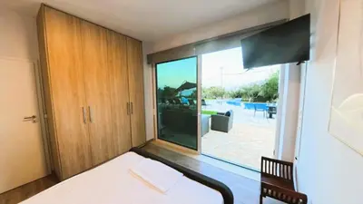 a bedroom with a bed and a large window at MG Residence Boutique Holiday Home in Korakiaí