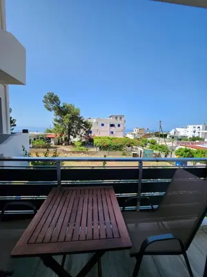 a wooden bench and a chair on a balcony at Tarra Rooms and Apartments in Agia Roumeli