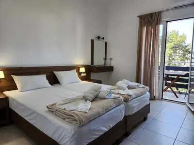 a bedroom with a large bed with towels on it at Tarra Rooms and Apartments in Agia Roumeli