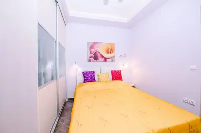 a bedroom with a yellow bed and a painting on the wall at Mary's modern apartment in Kissamos