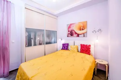a bedroom with a yellow bed with colorful pillows at Mary's modern apartment in Kissamos