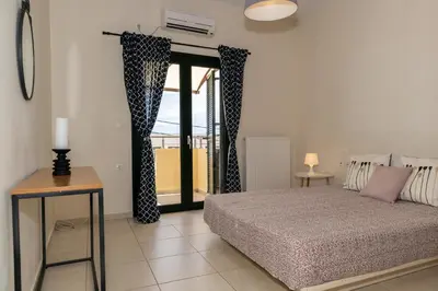 a bedroom with a bed and a sliding glass door at Maisonette in Koumpeli in Koumpeli