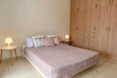 a bedroom with a bed with pillows and a cabinet at Maisonette in Koumpeli in Koumpeli