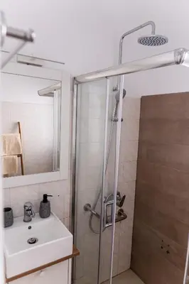 a bathroom with a shower and a sink at Central Kalyves Appartment - 5 min waking to the beach in Kalyves