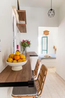 a kitchen with a bowl of oranges on a table at Central Kalyves Appartment - 5 min waking to the beach in Kalyves