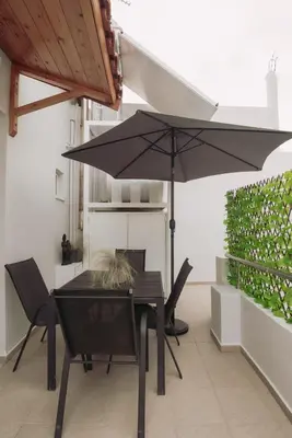 a table and chairs with an umbrella on a patio at Semeli House in Chania Town