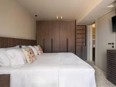 a bedroom with a large bed with white sheets and pillows at Villa Portokalea in Maleme