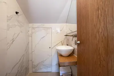 a bathroom with a sink and a glass shower at Versante Rousso - Modern Living in Nature's Embrace by etouri in Káïna