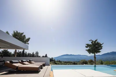 a villa with a swimming pool and a house at Versante Rousso - Modern Living in Nature's Embrace by etouri in Káïna