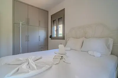 a white bed with white sheets and towels on it at Cretan Blue Bungalow Chania in Chania Town