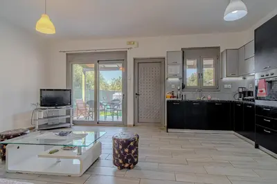 a kitchen with a glass table and a living room at Cretan Blue Bungalow Chania in Chania Town