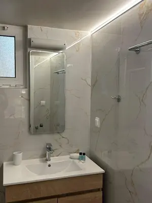 a bathroom with a sink and a shower with a mirror at EYTYXHS Studios in Palaiochóra