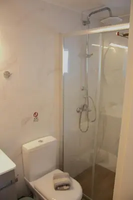 a bathroom with a toilet and a glass shower at EYTYXHS Studios in Palaiochóra
