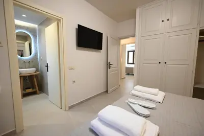 a bathroom with white towels on a table and a television at Unick Avra Luxury Living in Kalathas