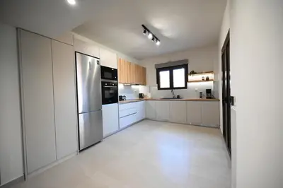 a kitchen with white cabinets and a stainless steel refrigerator at Unick Avra Luxury Living in Kalathas