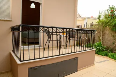 a balcony with a table and chairs on it at Happy House-Steps from Nea Chora Beach in Chania Town