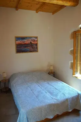 a bedroom with a blue bed in a room at The Village Hideaway - Traditional Stone House in Kissamos