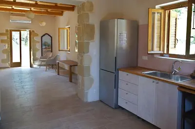 a kitchen with a refrigerator and a counter top at The Village Hideaway - Traditional Stone House in Kissamos