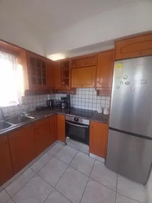 a kitchen with wooden cabinets and a stainless steel refrigerator at Emmanouil in Chania Town