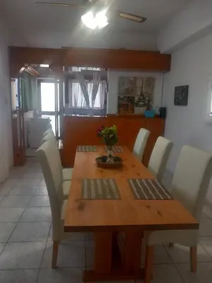 a dining room table with white chairs and a wooden table at Emmanouil in Chania Town