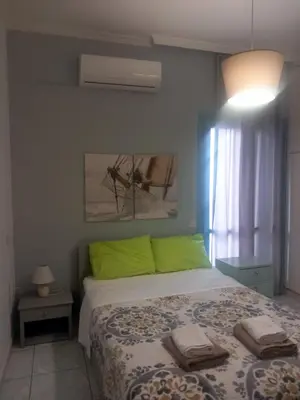 a bedroom with a bed with green pillows on it at Emmanouil in Chania Town