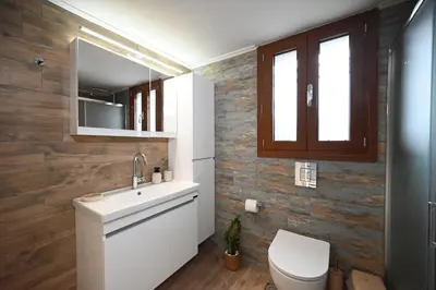 a bathroom with a toilet and a sink and a mirror at Unick Seaview Luxury Living in Kalathas