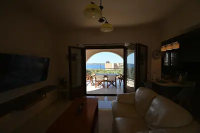 a living room with a couch and a view of a table at Unick Seaview Luxury Living in Kalathas