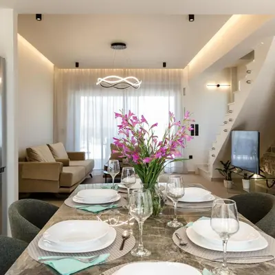 a dining room with a table with plates and wine glasses at Amfitriti Villa in Gramvousá