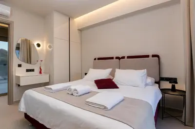 a bedroom with a large white bed with towels on it at Amfitriti Villa in Gramvousá