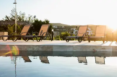 a group of chairs sitting next to a pool of water at Amfitriti Villa in Gramvousá