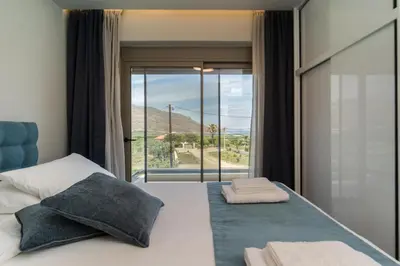 a bedroom with a bed with a large window at Amfitriti Villa in Gramvousá