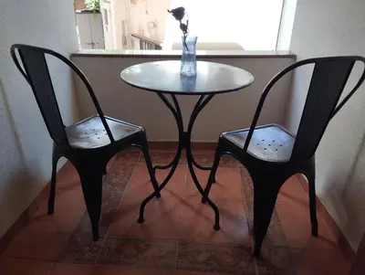 a table with two chairs and a table with a vase at Lili House in Chania Town