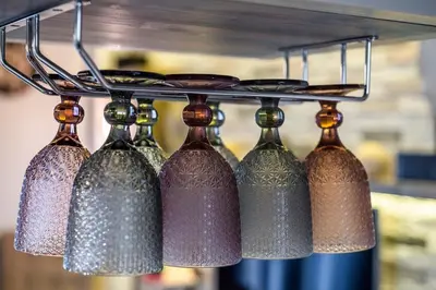 a group of wine bottles hanging from a rack at Cosy 1st floor apartment at Koum Kapi Beach in Chania Town