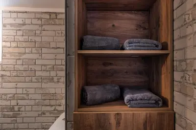 a wooden shelf with rolled towels in a bathroom at Cosy 1st floor apartment at Koum Kapi Beach in Chania Town