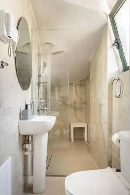 a bathroom with a sink and a toilet and a mirror at Manoli's Studios Old Town Chania in Chania Town