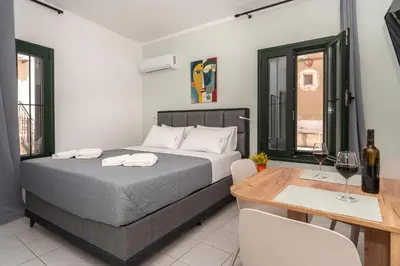 a bedroom with a bed and a table with wine glasses at Manoli's Studios Old Town Chania in Chania Town