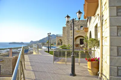 a street light on a sidewalk next to the ocean at Fotini Traditional Villas in Kavoúsion