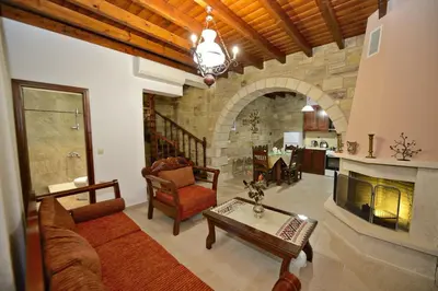 a living room with a couch and a fireplace at Fotini Traditional Villas in Kavoúsion